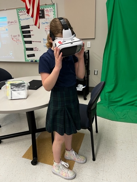 girl standing up with virtual reality learning headset on 