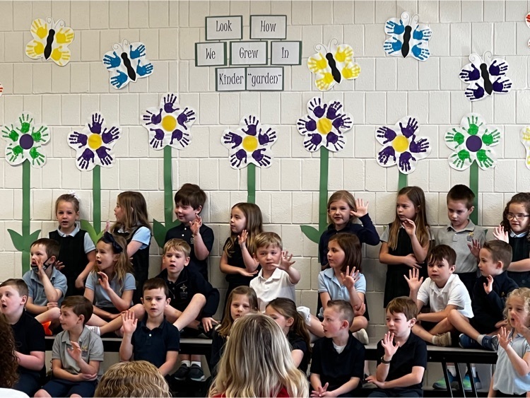 students holding up five fingers while reciting a poem 