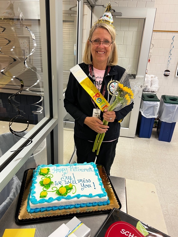 lady standing by retirement cake