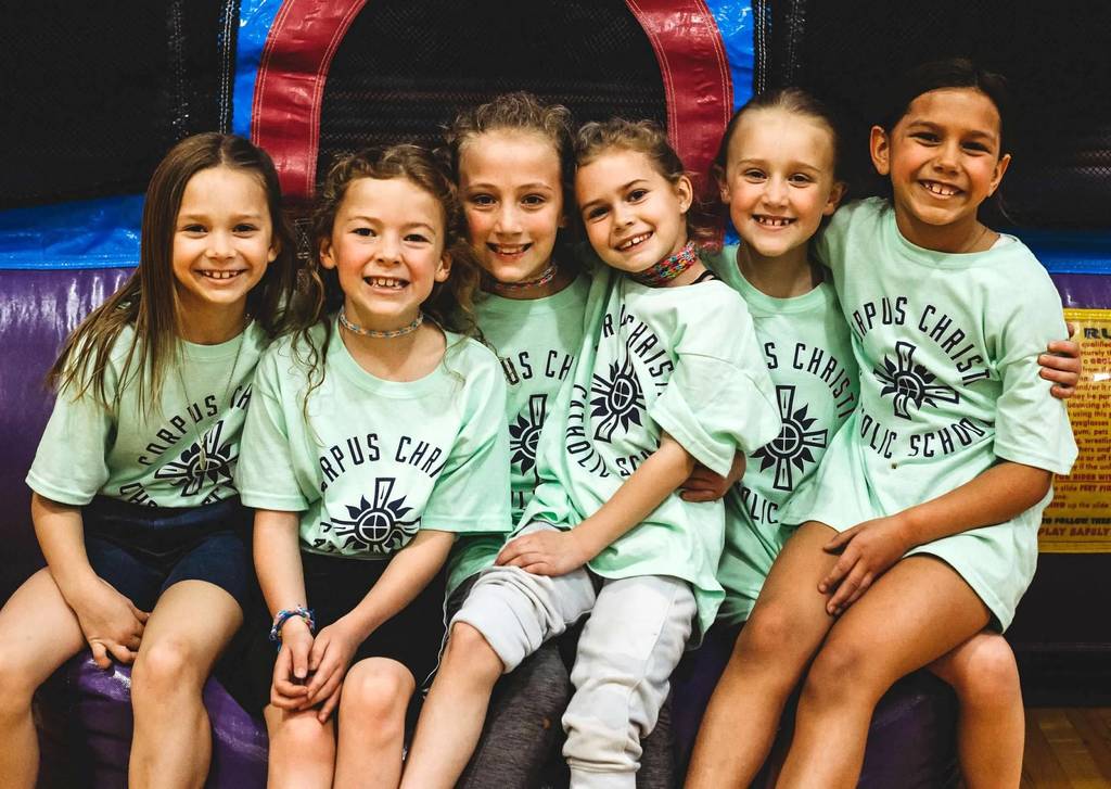 five girls wearing neon green shirts sitting together